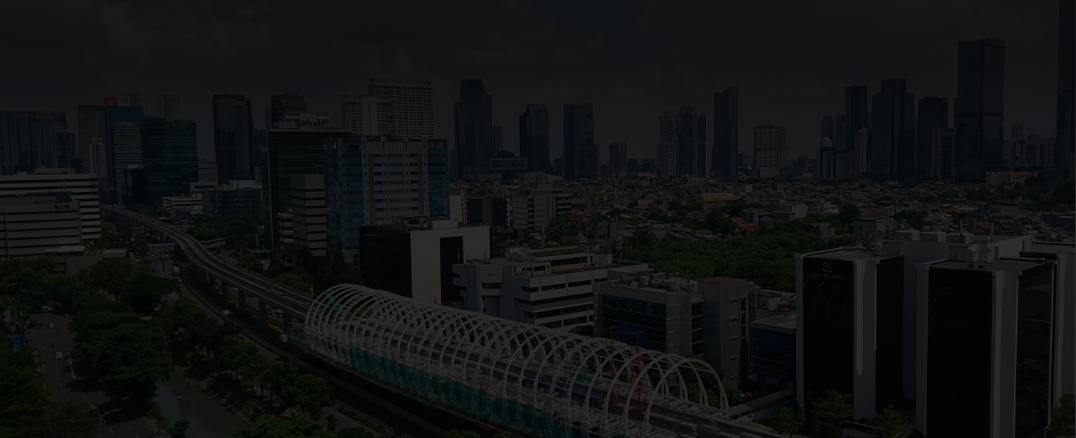 Cityscape background image showing tall buildings, roads, and greenery under a cloudy sky